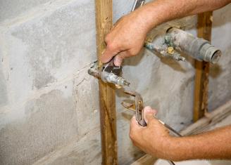 A licensed plumbing contractor in Aurora prepares to install a washing machine